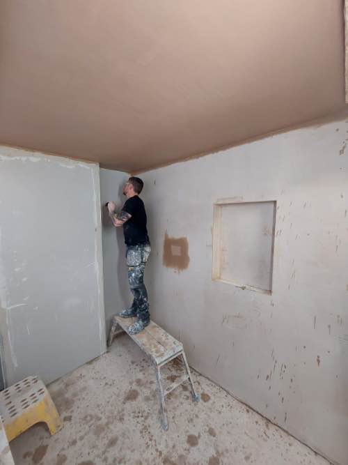 person plastering a ceiling