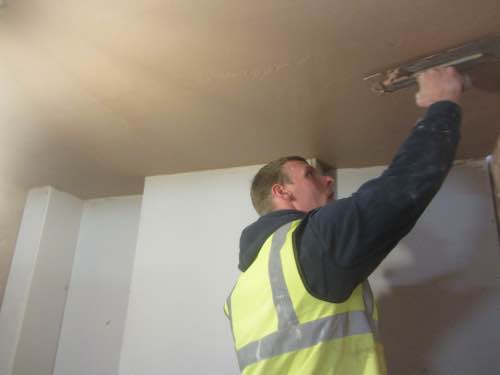 person applying multi finish to his ceiling