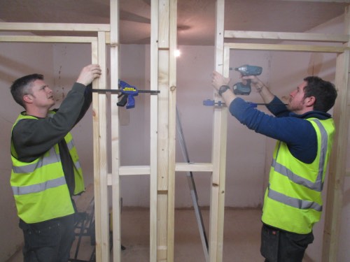 two people on carpentry course installing a door lining into their individual bays