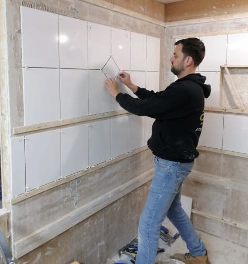 person tiling a tile in tile feature