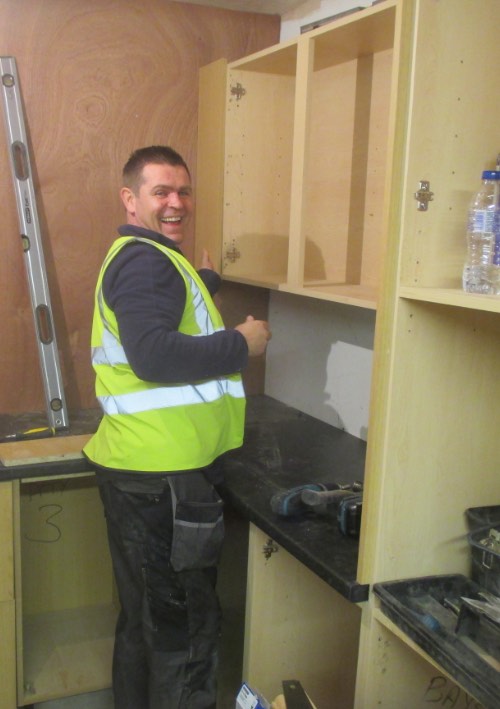 person from liverpool on a kitchen fitting course fitting doors to units