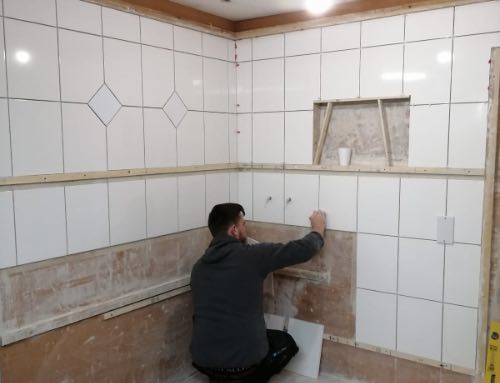 person tiling a wall with large format tiles
