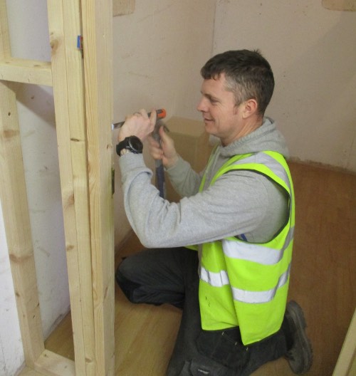 person chiselling a door lining