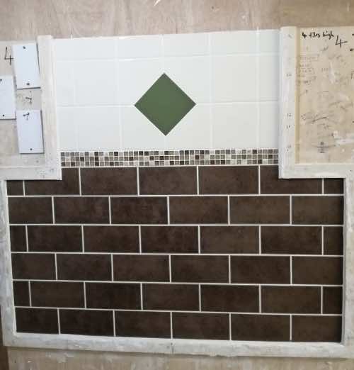 brick bond tiling with mosaic border and tile in tile design